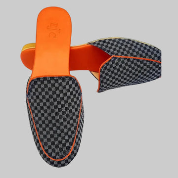 Pair of checkered loafers with orange accents on a white background
