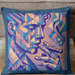 Decorative pillow with abstract face design on a couch