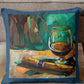 Decorative pillow with a painting of a glass of wine on a wooden table.