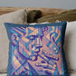 Decorative pillow with abstract face design on a couch