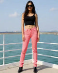 Woman wearing pink jeans and a black top on a boat with water and sky in the background