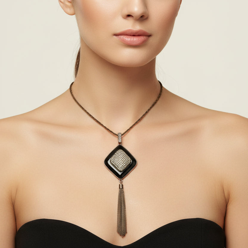 Necklace with a diamond-shaped pendant and tassel on a black mannequin bust.