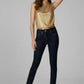 Woman wearing a gold top and dark jeans on a gray background