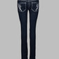 Black jeans with white embroidery on a gray background