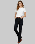 Woman wearing black jeans and a white t-shirt on a gray background