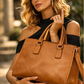 Woman holding a Deep Tan faux leather handbag outdoors