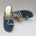 Blue sandal with gold embellishments on a light gray background