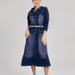 Woman wearing a long denim dress with a belt on a white background