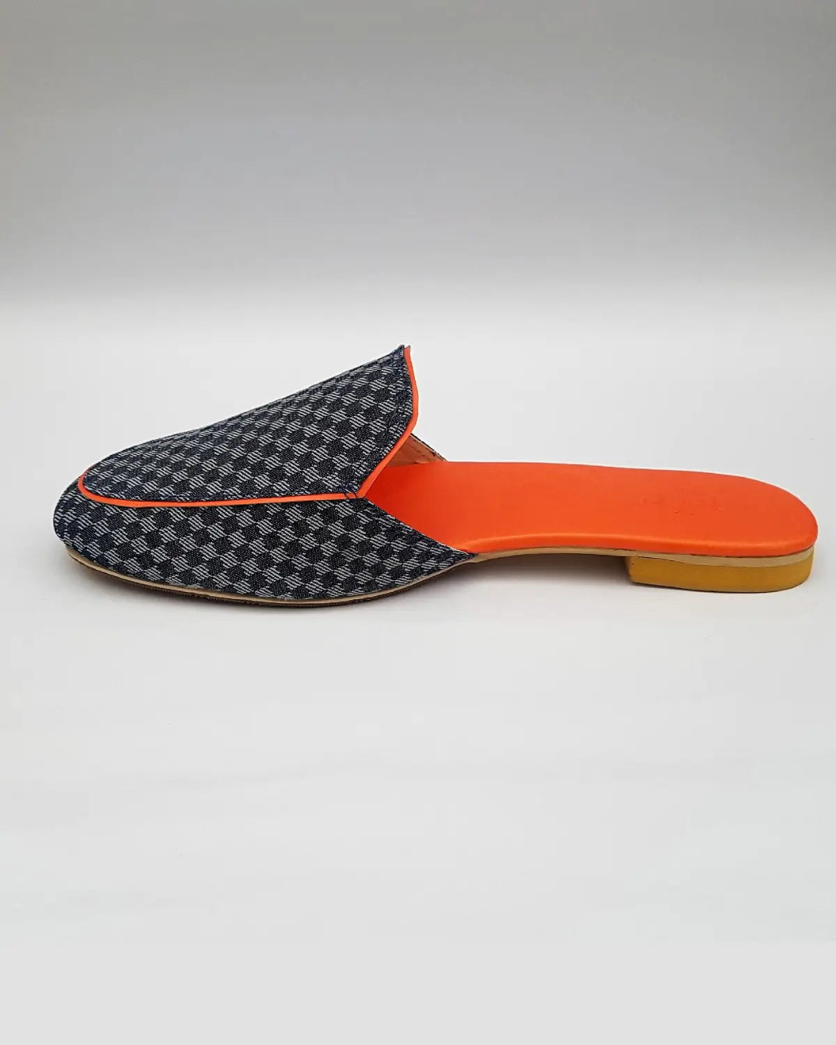 Slipper with checkered pattern and orange insole on a light gray background