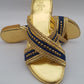Gold sandal with blue strap on a gray background
