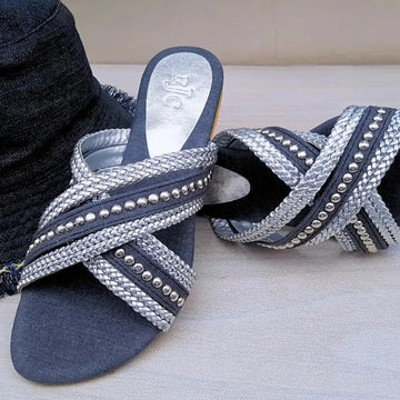 Pair of blue sandals with silver embellishments on a light background