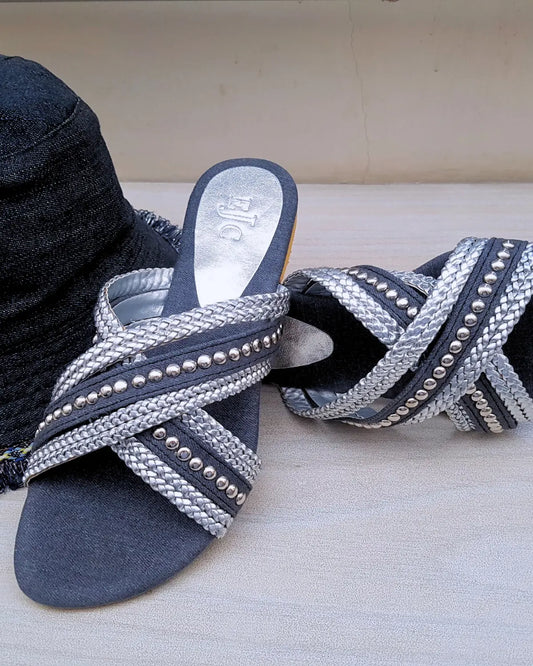Pair of blue sandals with silver embellishments on a light background