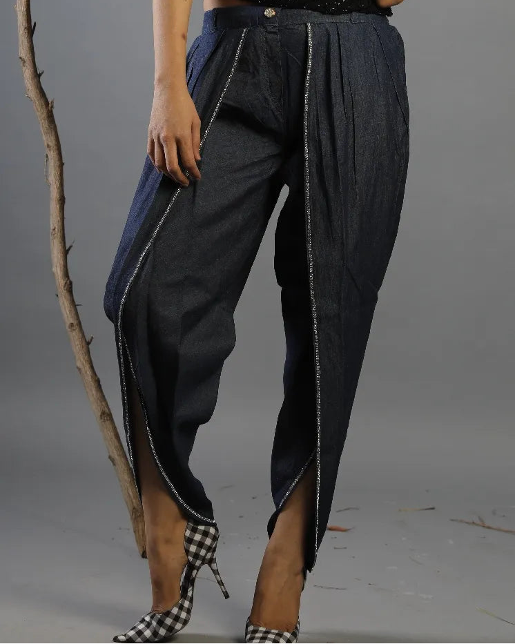 Person wearing dark blue pants with white trim on a gray background