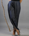 Person wearing a unique denim outfit with a gray background