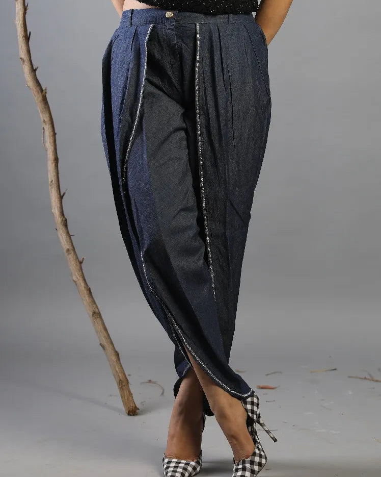 Person wearing a unique denim outfit with a gray background