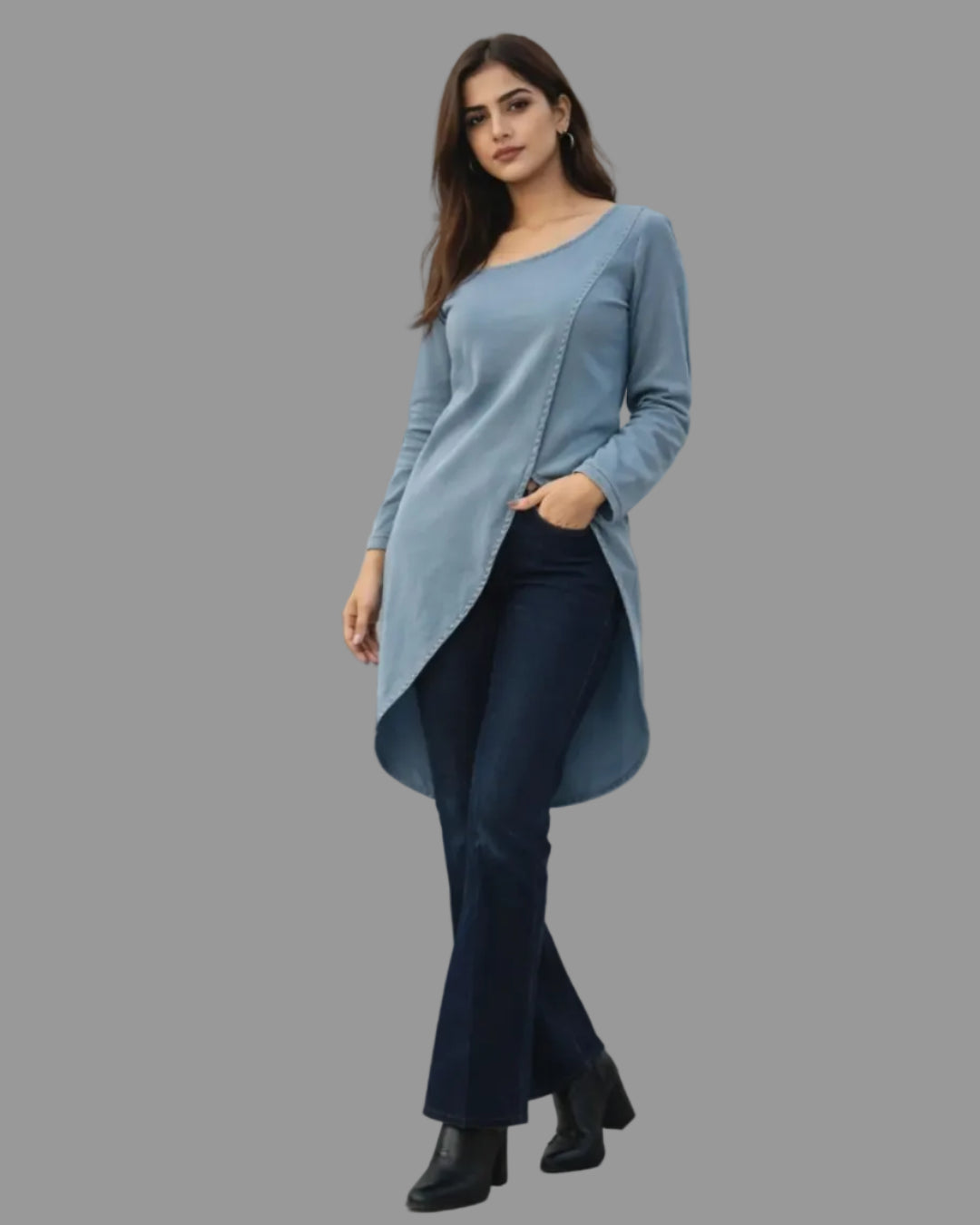 Woman wearing a denim long-sleeve top and dark pants standing in front of a cityscape window.