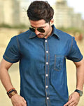 Man wearing a blue denim shirt with sunglasses outdoors