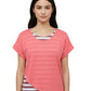 Woman wearing a coral pink t-shirt over a striped shirt on a plain background