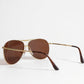 Aviator sunglasses with gold frame and brown lenses on a white background