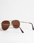 Aviator sunglasses with gold frame and brown lenses on a white background
