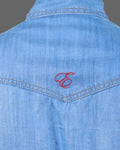 Blue denim shirt with a red embroidered letter 'E' on a white background