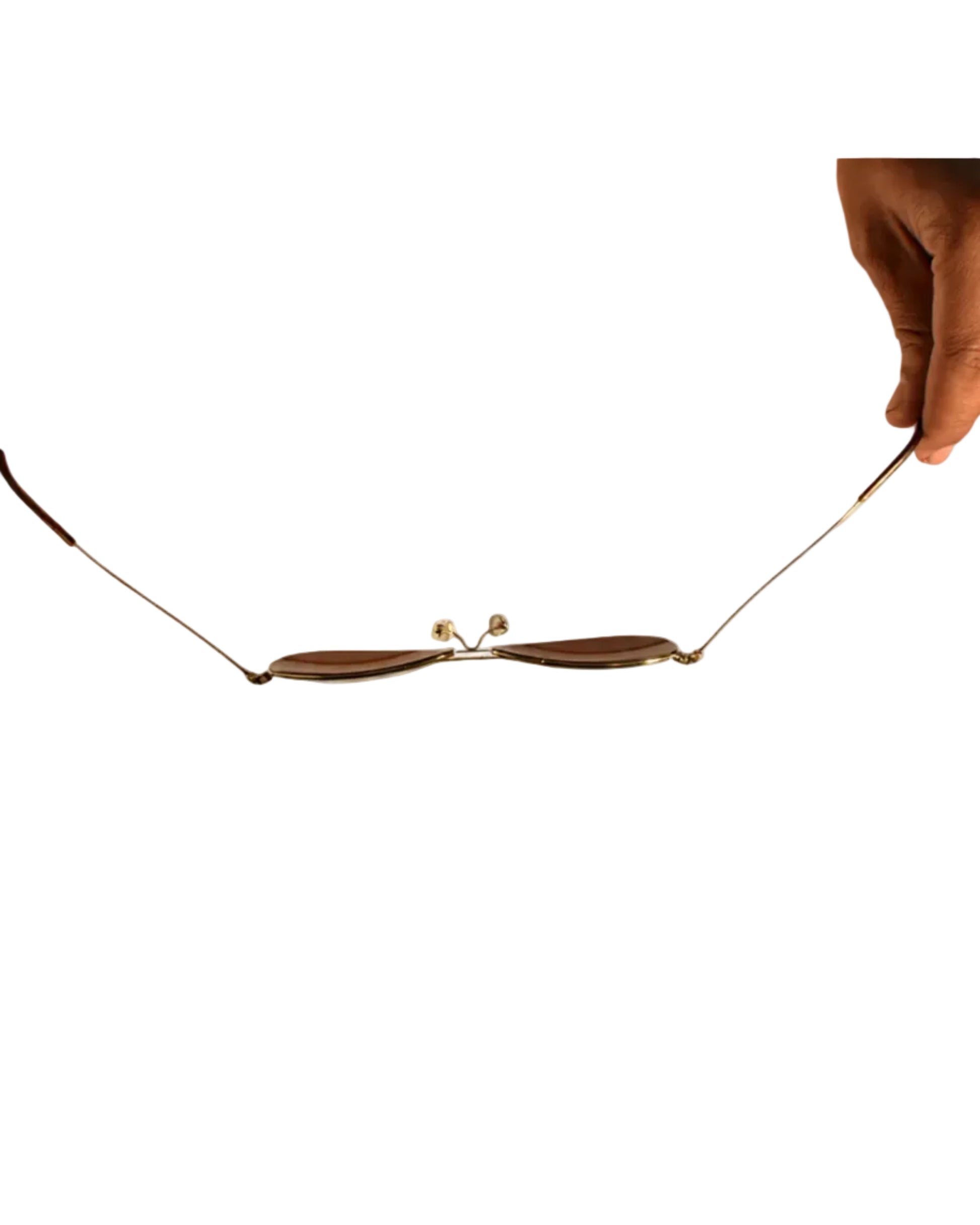 Gold necklace being held by two hands on a white background