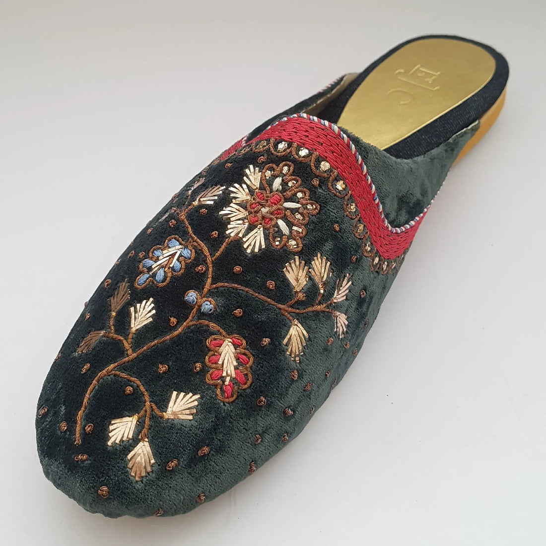 Pair of embroidered slippers with floral patterns on a white background