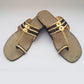 Pair of decorative sandals with gold and black accents on a white background