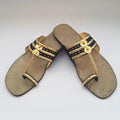 Pair of decorative sandals with gold and black accents on a white background
