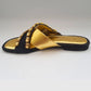 Black sandal with gold accents on a white background