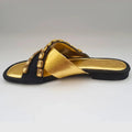 Black sandal with gold accents on a white background
