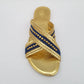 Gold sandal with blue strap on a light gray background