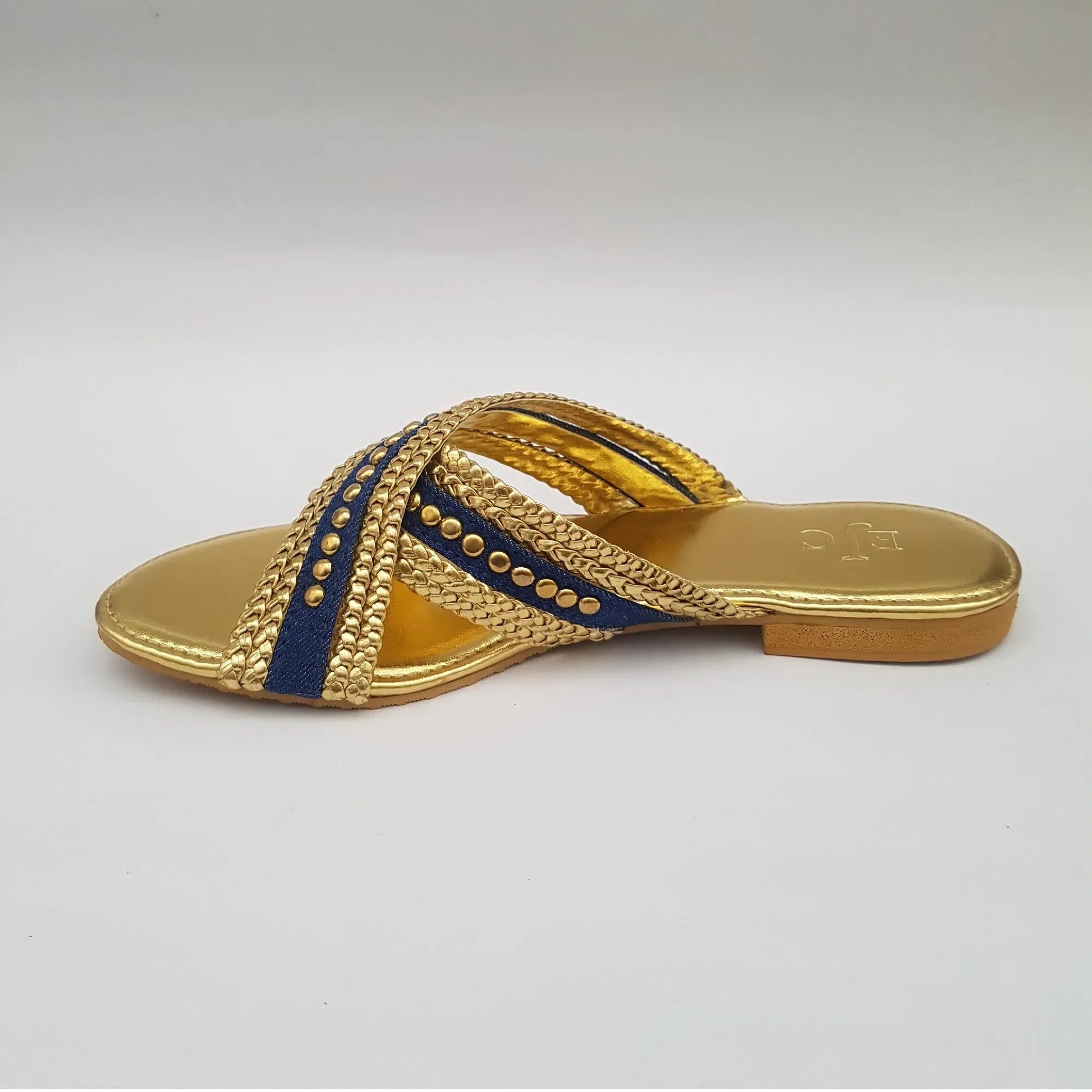 Gold sandal with blue accents on a light gray background