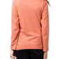 Person wearing a coral long-sleeve top on a plain background