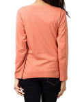 Person wearing a coral long-sleeve top on a plain background