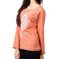 Person wearing a coral long-sleeve shirt with white text on a plain background