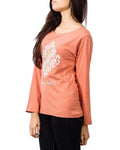 Person wearing a coral long-sleeve shirt with white text on a plain background