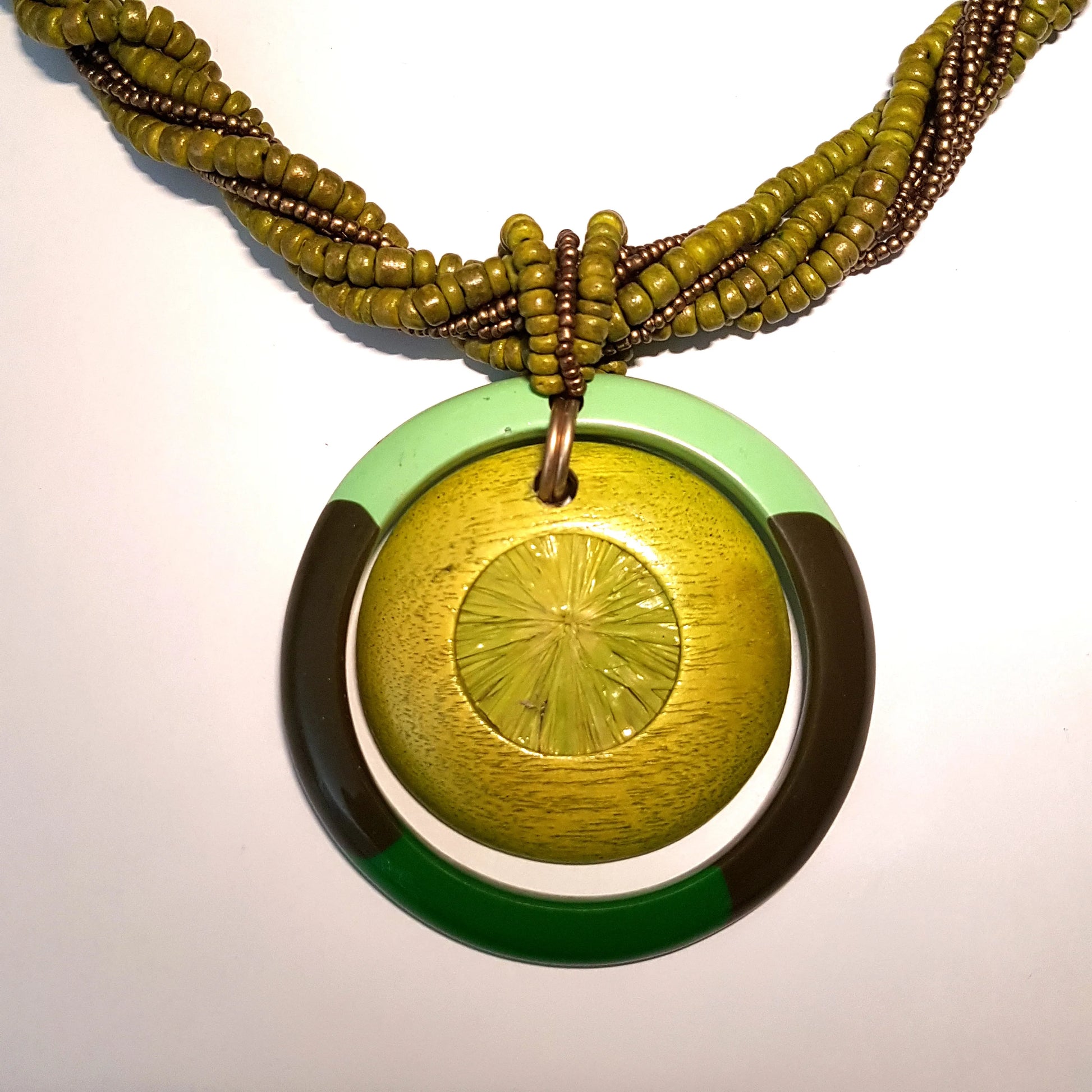 Necklace with green and gold pendant on a white background