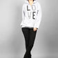 Person wearing a white hoodie with 'LOVE' printed on it against a gray background