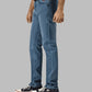 Person wearing blue jeans and black sneakers on a gray background