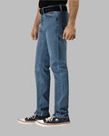 Person wearing blue jeans and black sneakers on a gray background