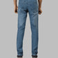 Blue jeans worn by a person on a gray background
