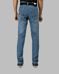 Blue jeans worn by a person on a gray background