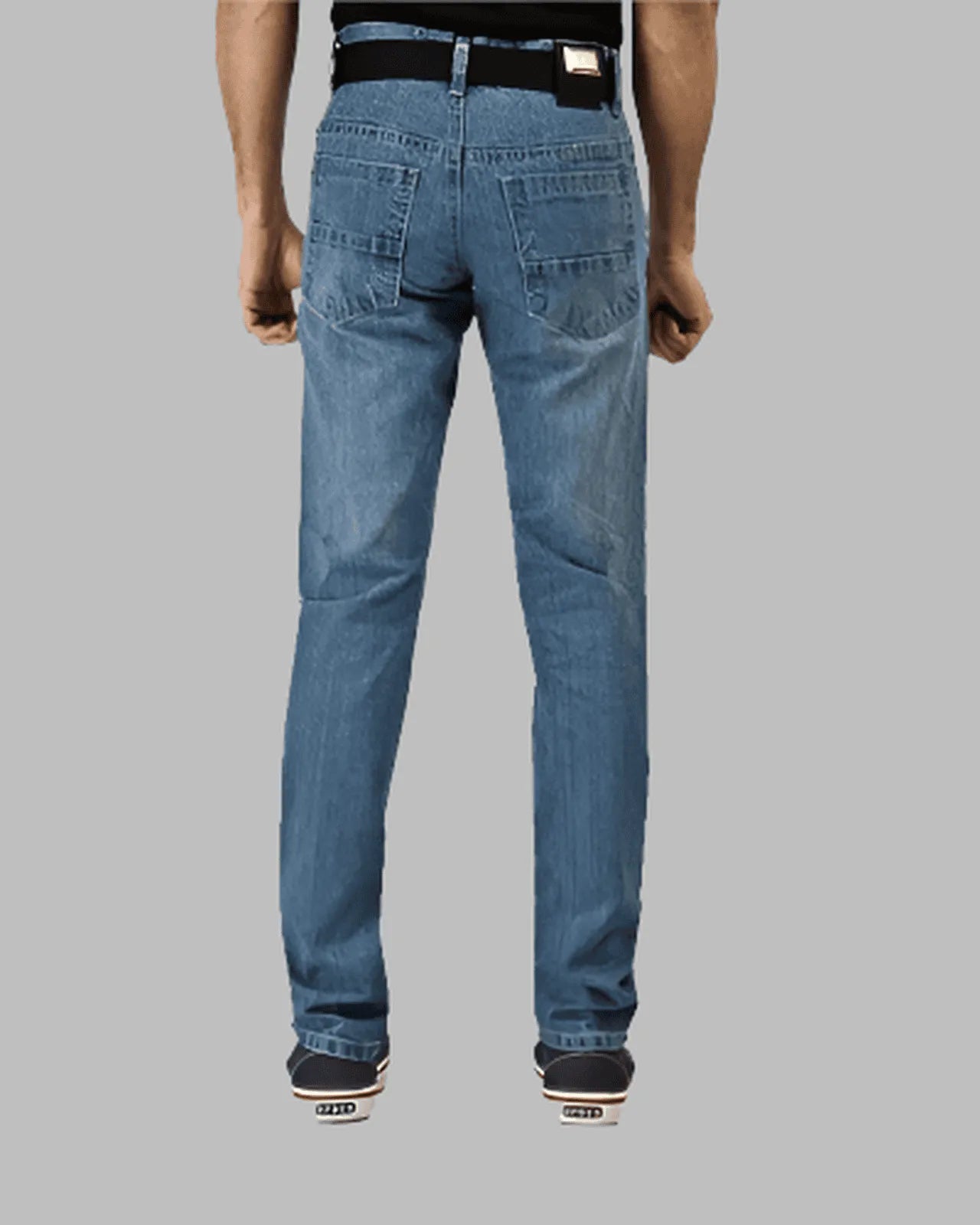 Blue jeans worn by a person on a gray background