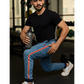 Man in black t-shirt and blue jeans with red stripes holding a water bottle in a gym setting