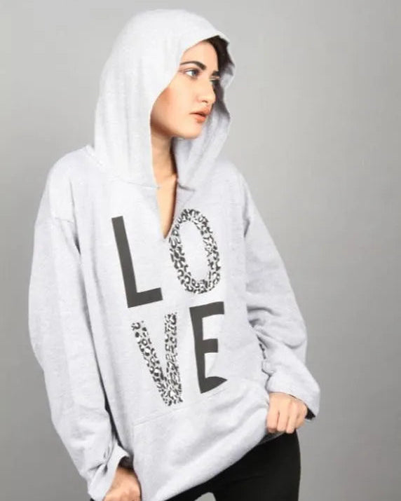 Person wearing a gray hoodie with 'LOVE' printed on it against a gray background