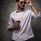 Man wearing sunglasses and holding a coffee cup against a dark background