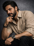 Man wearing a beige shirt and black pants with a dark background