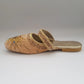 Decorative sandal with gold embellishments on a gray background