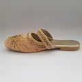 Decorative sandal with gold embellishments on a gray background